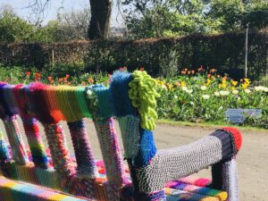 Knitted bench cover in park